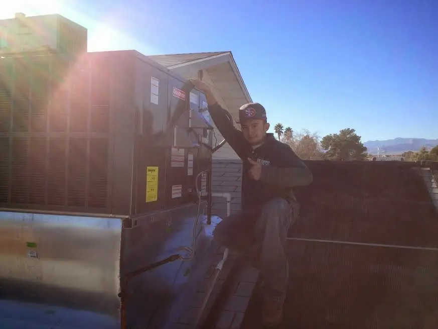 HVAC technician performing AC Tune-Up on a rooftop unit in Milton